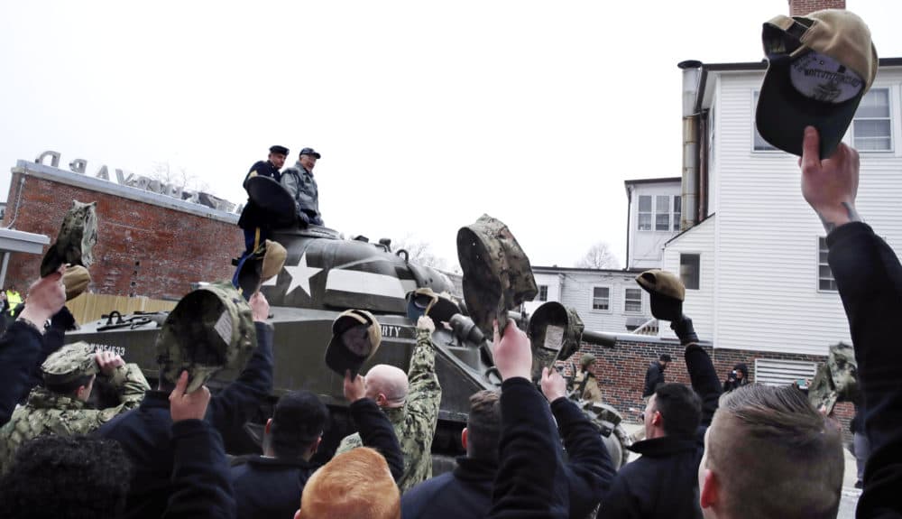 Sailors stationed with the historic frigate U.S.S. Constitution doff their caps as World War II tank gunner Clarence Smoyer enters the Charlestown Naval Shipyard in Boston. (Charles Krupa/AP)