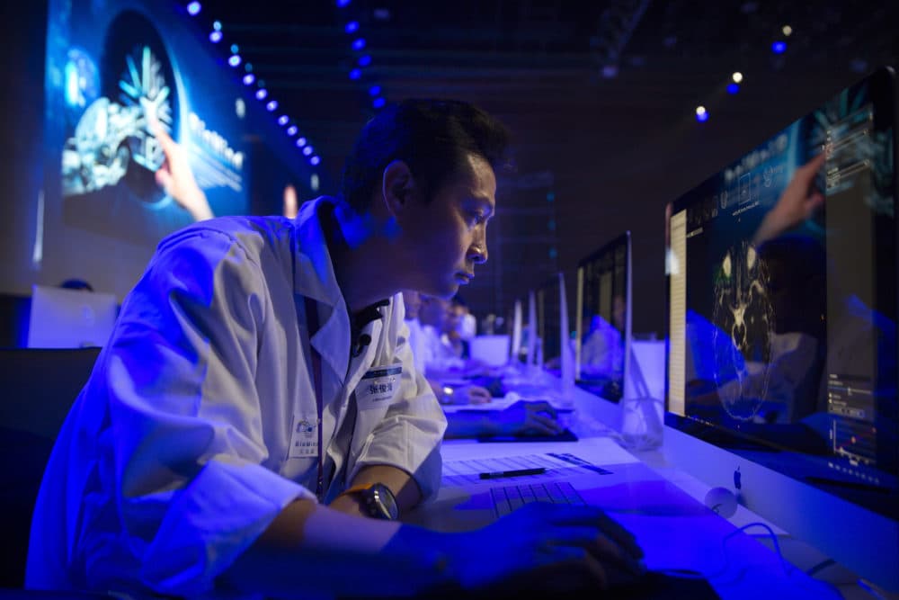 A doctor examines a magnetic resonance image of a human brain during the CHAIN Cup at the China National Convention Center in Beijing, June 30, 2018. A computer running artificial intelligence software defeated two teams of human doctors in accurately recognizing maladies in magnetic resonance images on Saturday, in a contest that was billed as the world's first competition in neuroimaging between AI and human experts. (Mark Schiefelbein/AP)