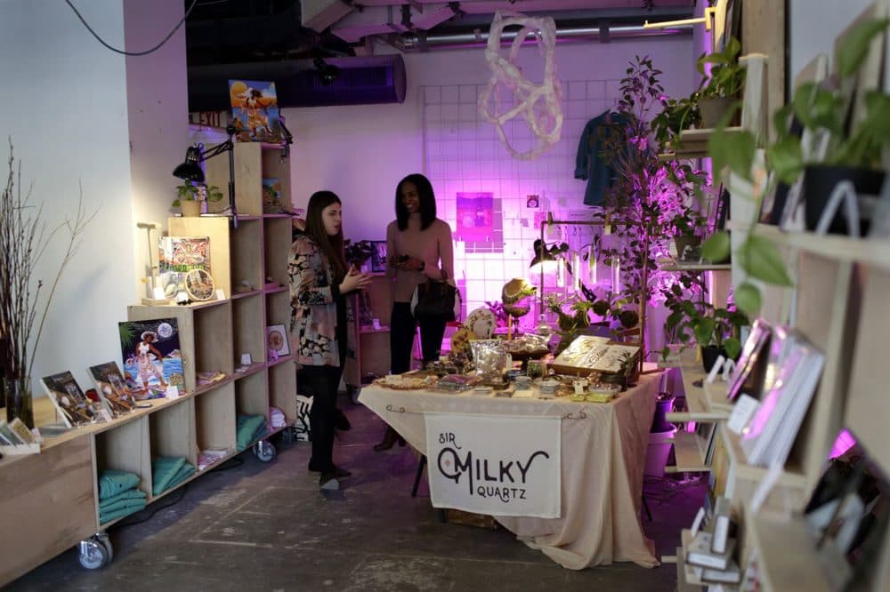 Spaceus members Savannah Marie and Nada Shuaib speak during Marie's pop-up for her store, Sir Milky Quartz, at Spaceus in Cambridge (Hadley Green for WBUR)