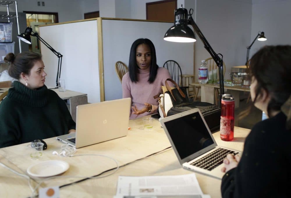 Members speak in the co-working space at Spaceus in East Cambridge. (Hadley Green for WBUR)