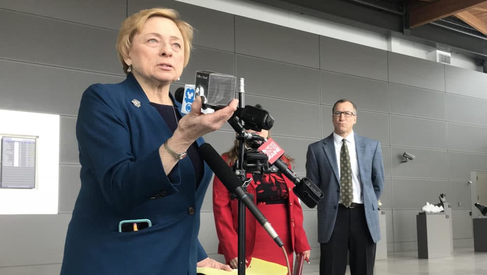 Maine Gov. Janet Mills holds up a pound of carbon at a press conference at the Portland Jetport on Thursday. (Fred Bever/Maine Public)