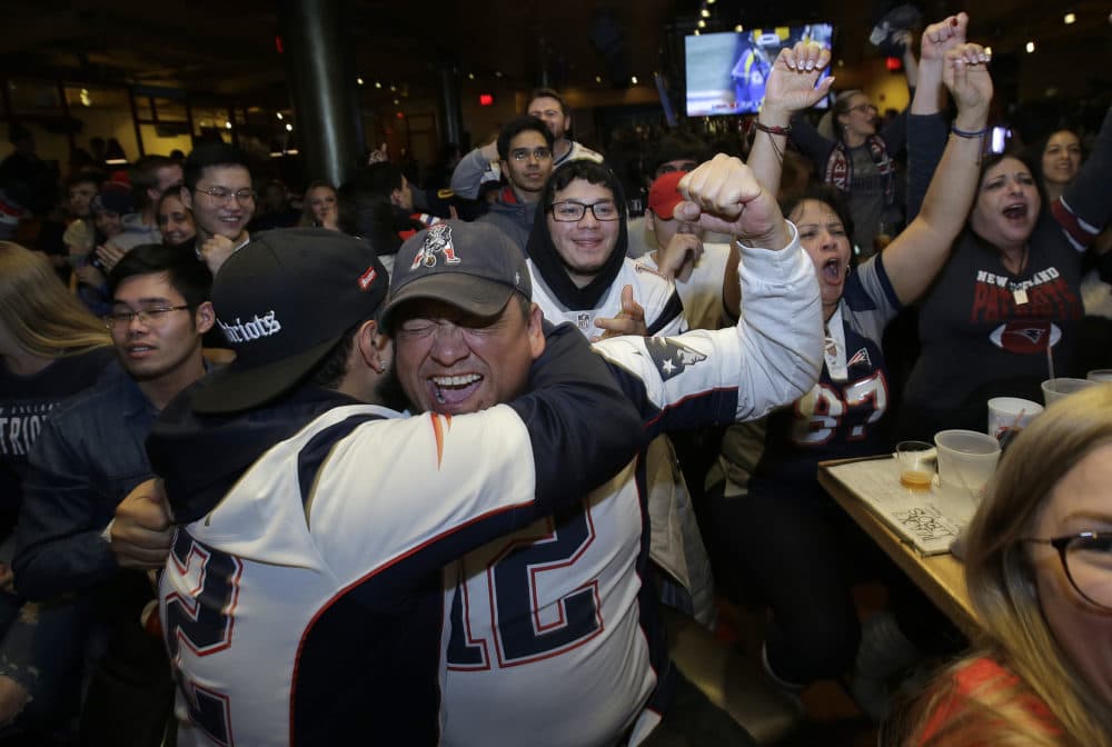 Victor Polanco, center, cheers with others while watching the second half of the game. (Steven Senne/AP)