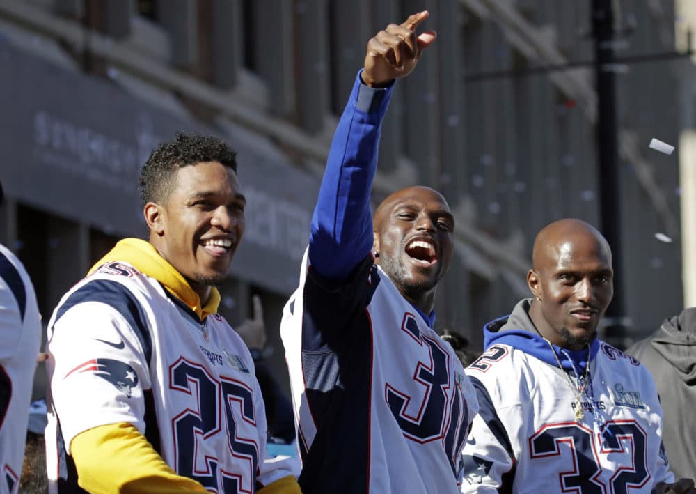 From left: Patriots Eric Rowe, Jason McCourty and Devin McCourty react to fans. (Elise Amendola/AP)