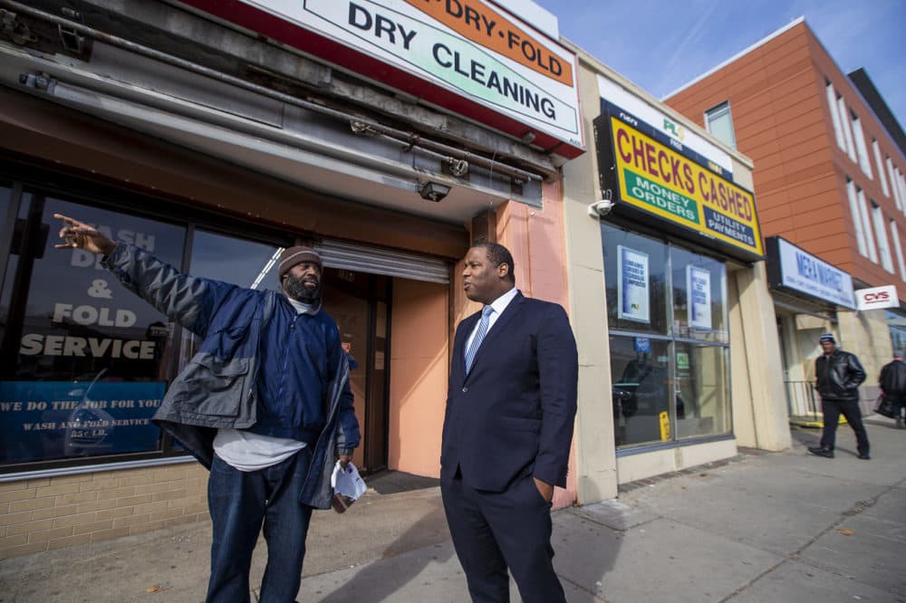 Rodney Weaver, left, speaks with former Boston City Councilor Tito Jackson about the prospect of jobs at the marijuana dispensary Jackson wants to open in Mattapan Square. (Jesse Costa/WBUR)