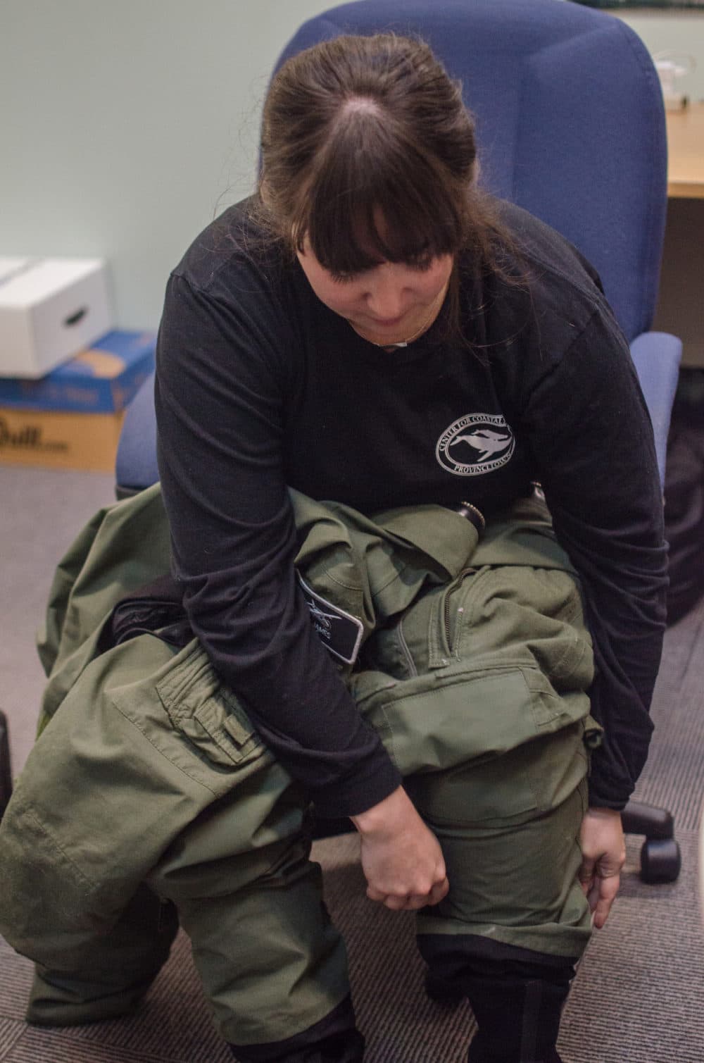 Amy James puts on her flight suit before a survey (Sharon Brody/WBUR)