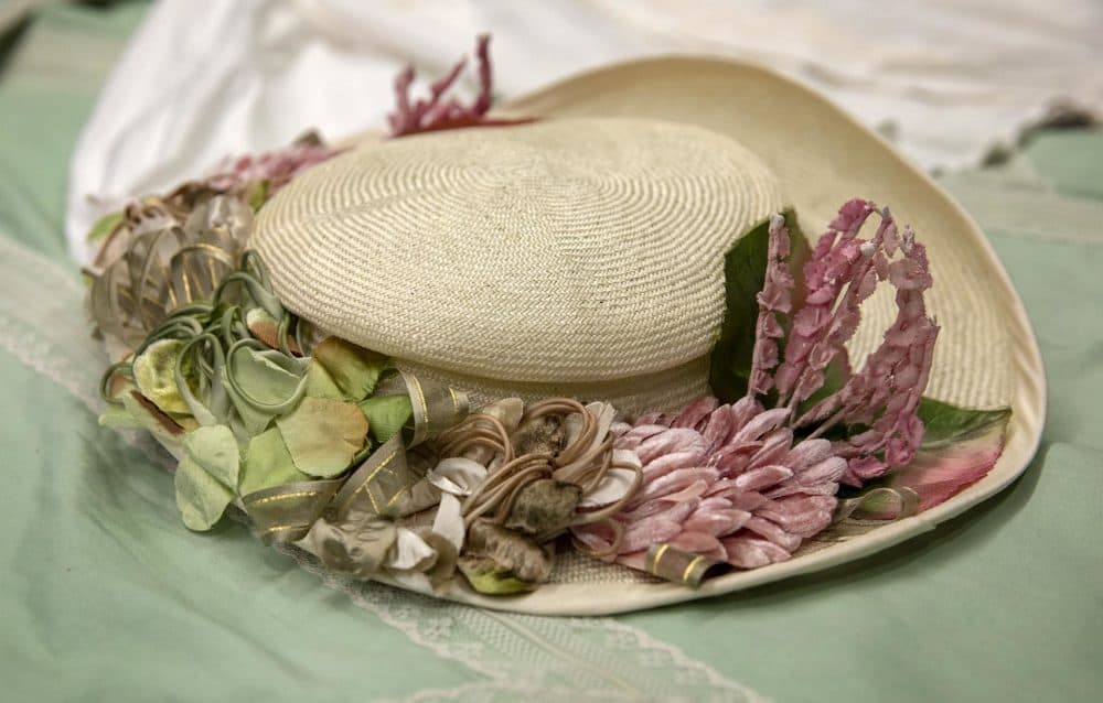 A parasisal straw hat trimmed with pink flowers, by Quinn Burgess. (Robin Lubbock/WBUR)