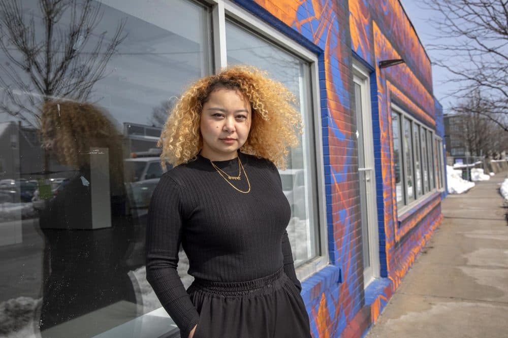 Shrestha at her mural &quot;Saya Patri (The One With A Hundred Petals)&quot; on Western Ave. in Boston. (Robin Lubbock/WBUR)