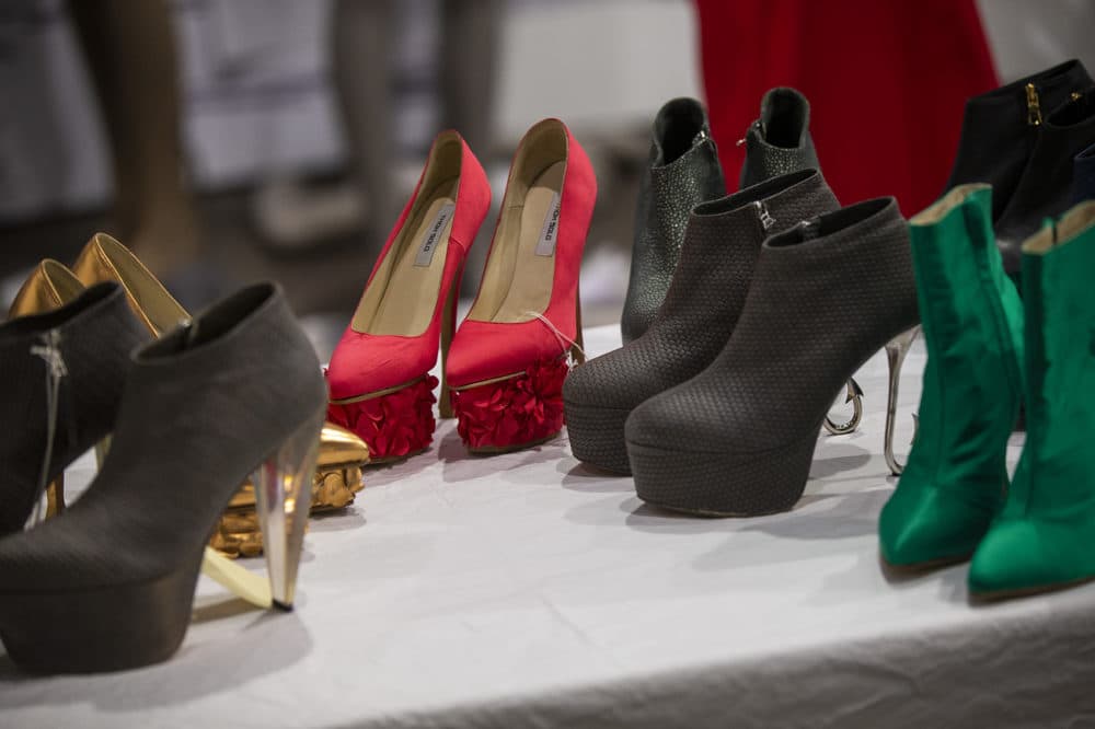 Shoes designed by Newton native Thom Solo are set out on a work table ready to be placed on the mannequins in the show. (Jesse Costa/WBUR)