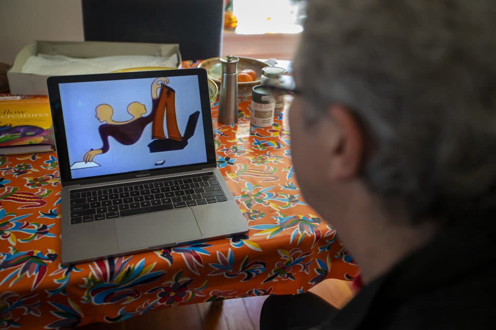 Ken Field watches the animation created by his late wife, animator Karen Aqua, entitled “Vis A Vis.” (Jesse Costa/WBUR)