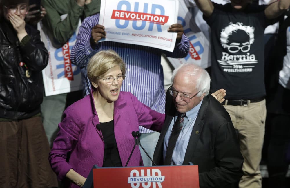 Sens. Elizabeth Warren, D-Mass., and Bernie Sanders, I-Vt., greet one another during a 2017 rally in Boston. Now they're both running for president. (Steven Senne/AP)