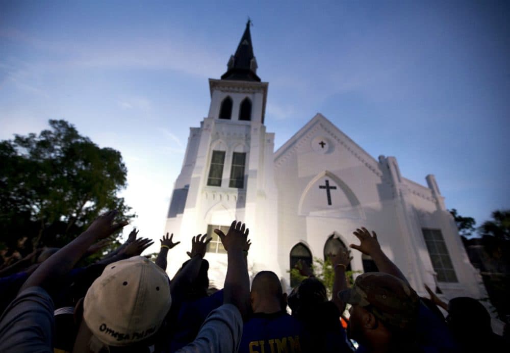 The men of Omega Psi Phi Fraternity Inc. lead a crowd of people in prayer outside the Emanuel AME Church in Charleston, S.C on June 6, 2015. (Stephen B. Morton/AP)