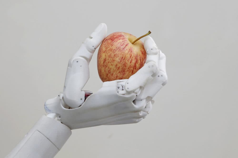 Hanson Robotics' flagship robot Sophia, a lifelike robot powered by artificial intelligence, holds an apple in Hong Kong. (Kin Cheung/AP)