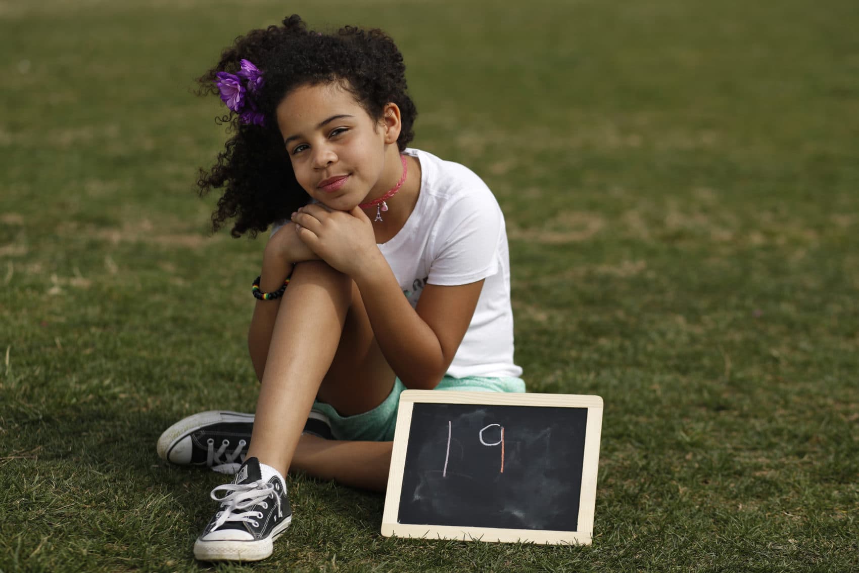 Havana Chapman-Edwards, 8, of Washington, sits by a chalkboard with her age in 2030, the point where the globe would be stuck on a path toward what scientists call planet-changing dangerous warming, Friday, March 15, 2019, during a climate change rally of students in Washington. "Borders, languages and religions do not separate us," said Chapman-Edwards at the U.S. Capitol. (Jacquelyn Martin/AP)