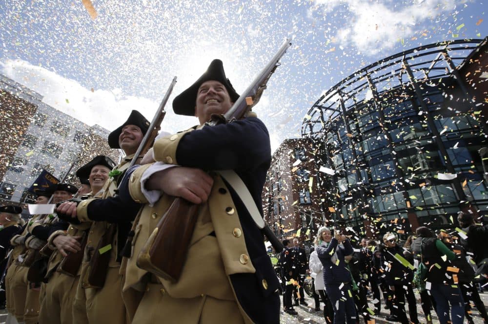 Lexington Minutemen Revolutionary War re-enactors hold their rifles as confetti falls at the start of the annual St. Patrick's Day parade. (Steven Senne/AP)