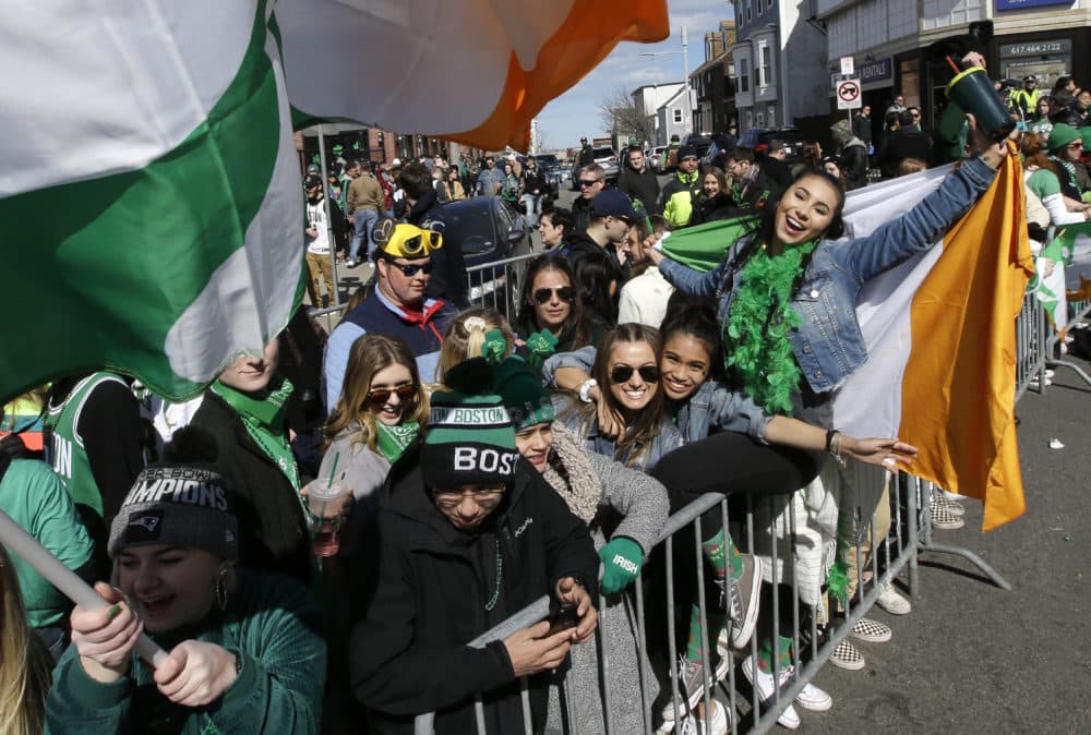 Spectators hold flags and cheer during the annual St. Patrick's Day parade, Sunday, March 17, 2019, in South Boston. (Steven Senne/AP)