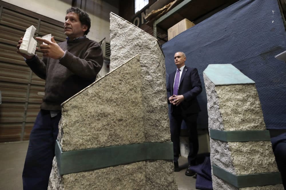 Artist Pablo Eduardo, left, speaks about granite pillars which will be part of a permanent memorial to the victims of the 2013 Boston Marathon bombings. Listening at right is Boston's Chief of Operations Patrick Brophy. (Elise Amendola/AP)