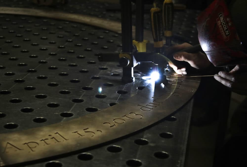 A blowtorch is used on a bronze ring with inscription as work continues on a permanent memorial to the victims of the Boston Marathon bombings. (Elise Amendola/AP)
