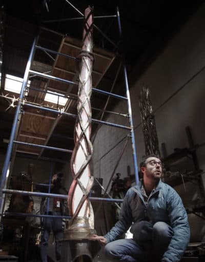 Lighting designer Dan Weissman turns on a tower light which will be part of a permanent memorial to the victims of the 2013 Boston Marathon bombings at a foundry in Chelsea, Mass. (Elise Amendola/AP)
