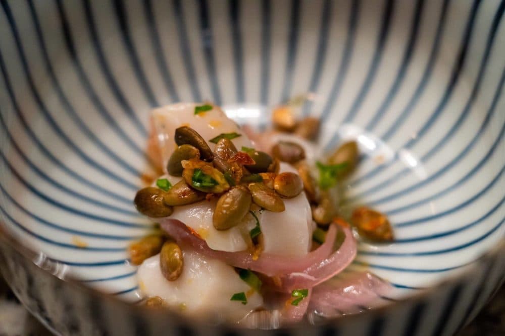 This scallop crudo dish, created by Dope Dinners, features lacto-fermented red onion, lime juice, toasted pepitas, CBD tomato salt. (Courtesy)