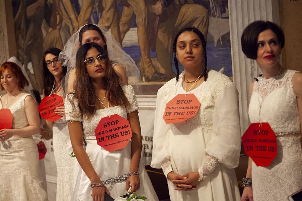 Demonstrators gathered at the State House Wednesday wearing wedding gowns, chains and placards demanding passage of a bill to close what they described as a loophole allowing individuals under 18 to be married. (Chris Lisinski/SHNS)