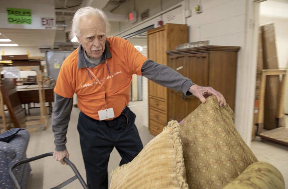 Ira Smith gets to work moving a large chair at Household Goods in Acton, Mass. (Robin Lubbock/WBUR)