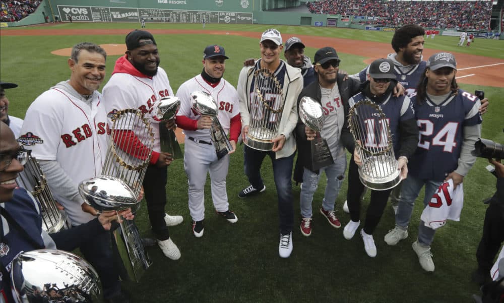 Patriots and Red Sox players hold Super Bowl and World Series trophies. From left they are, Patriots' Matthew Slater, Red Sox's Mike Lowell, David Ortiz and Steve Pearce, Patriots' Rob Gronkowski, Patrick Chung, Julian Edelman, and Stephon Gilmore (24). At rear are Duron Harmon, behind Gronkowski, and New England Patriots' Deatrich Wise, behind Edelman. (Charles Krupa/AP)