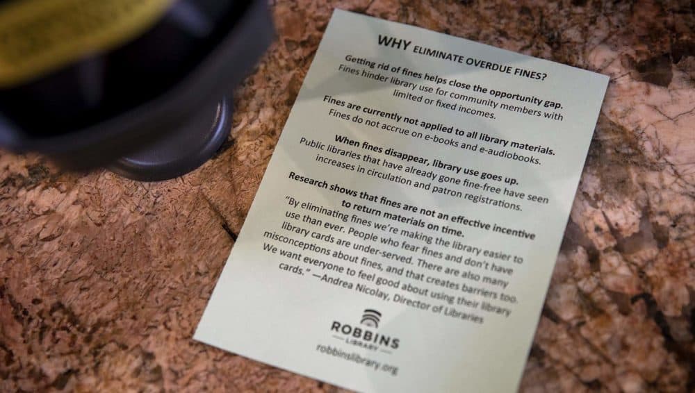 A small leaflet explains why the Robbins Library has eliminated fines for overdue books. (Robin Lubbock/WBUR)