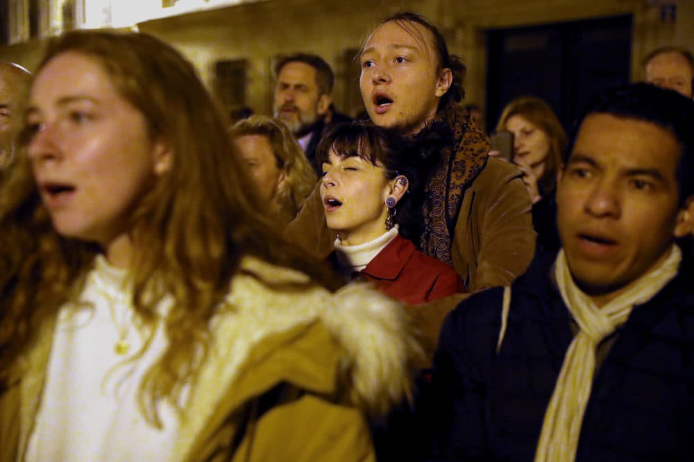 Worshippers sing religious songs as firefighters battle to extinguish a fire that engulfed the Notre Dame Cathedral. (Courtesy of Maya Vidon-White)