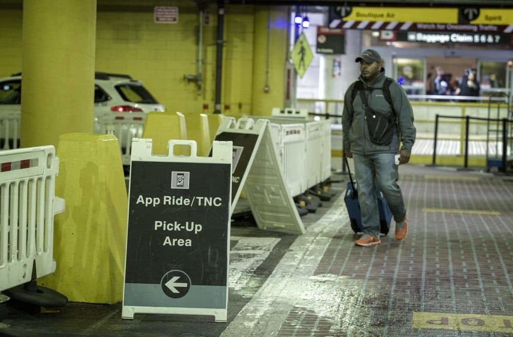 A passenger walks to the app ride pick-up area at Logan’s Terminal B. (Robin Lubbock/WBUR)
