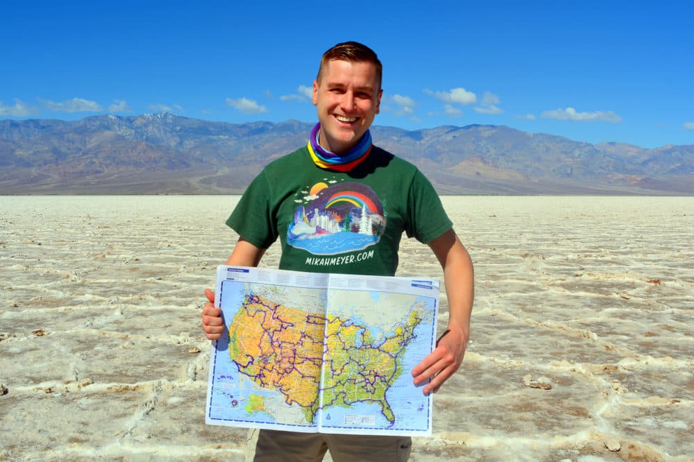 Mikah Meyer holds up a map of his journey at his 313th stop: Badwater Basin in Death Valley National Park, the lowest point in North America. (Courtesy of Mikah Meyer)