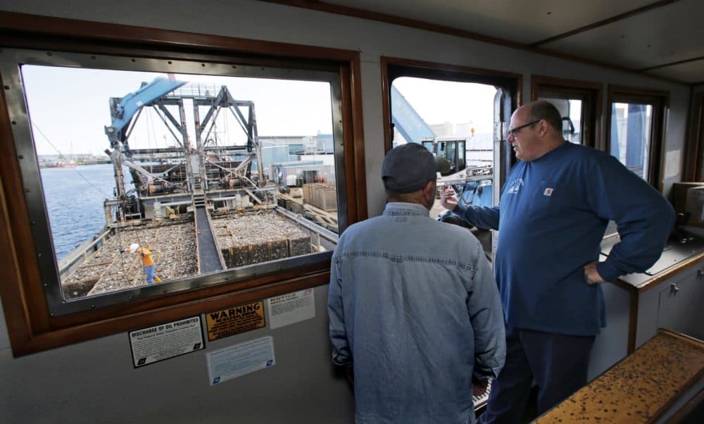 In this May 2016 photo, Mike Mohr, right, captain of the fishing vessel E.S.S. Pursuit, talks with his first mate while offloading a two-day haul of quahog clams at a dock in New Bedford, Mass. (Charles Krupa/AP)