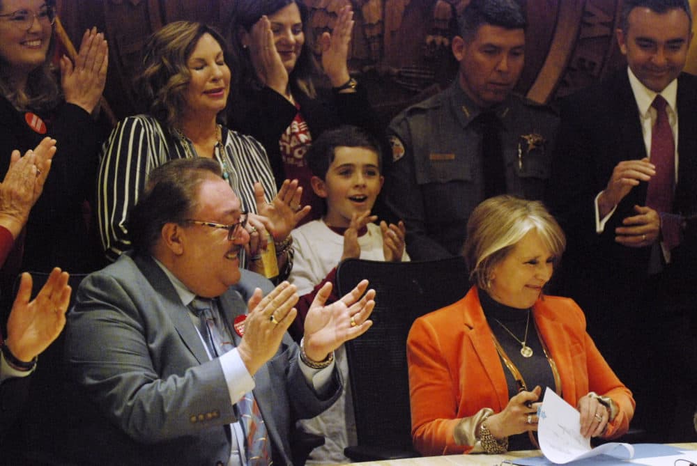 New Mexico Gov. Michelle Lujan Grisham signs a bill into law that expands background checks to nearly all gun sales in New Mexico in a ceremony in in Santa Fe, N.M., Friday, March 8, 2019. (Morgan Lee/AP)