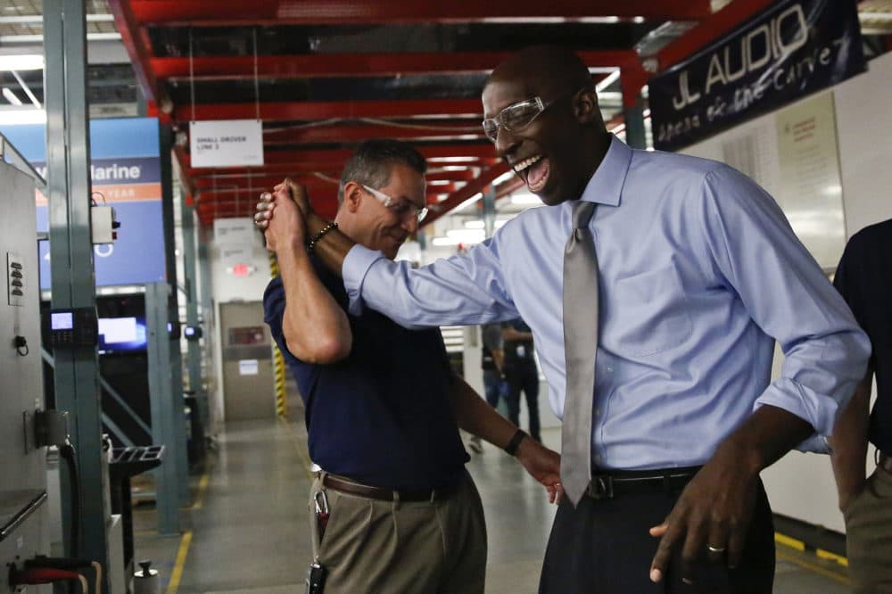 Miramar Mayor Wayne Messam, right, laughs with Stephen Turrisi, left, the director of training and technical services at JL Audio during a tour in Miramar, Fla. (Brynn Anderson/AP)