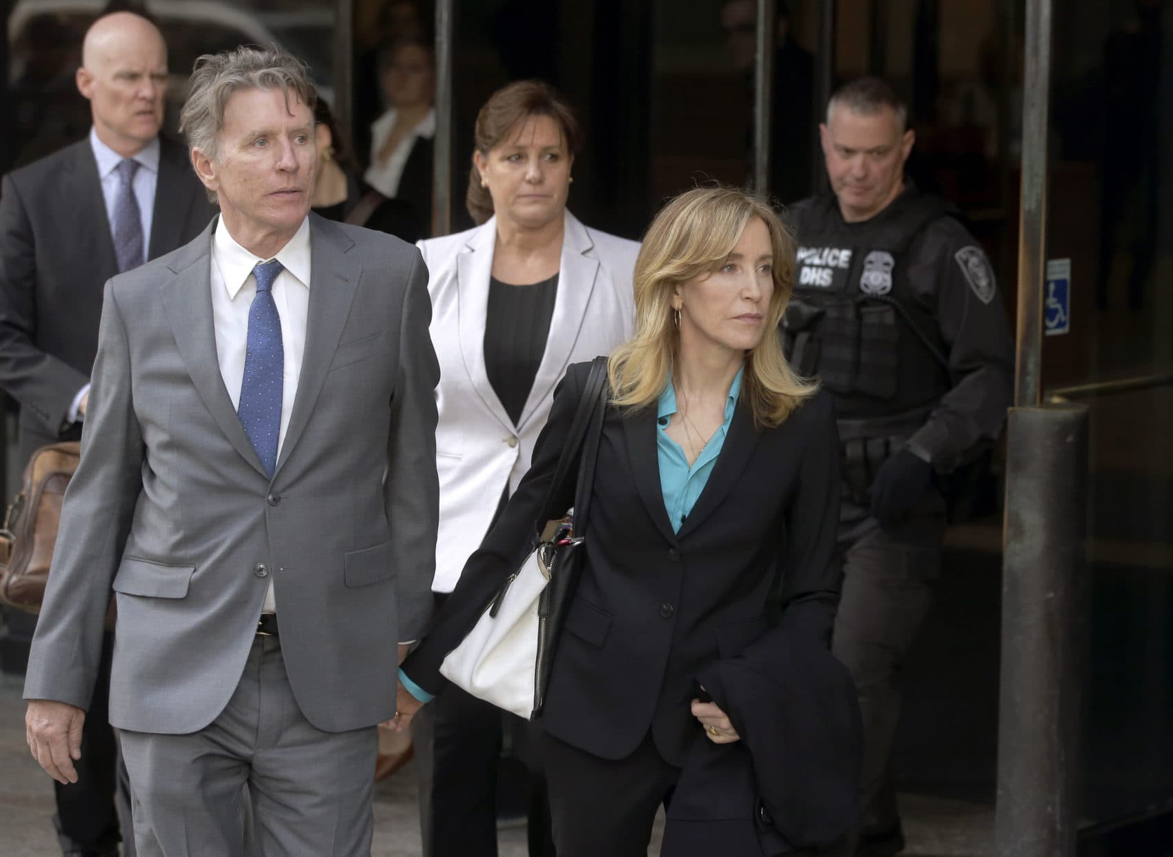 Actress Felicity Huffman departs federal court in Boston with her brother Moore Huffman Jr., left, on Wednesday, April 3, 2019, after facing charges in a nationwide college admissions bribery scandal. (Steven Senne/AP)