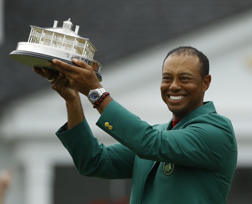 Tiger Woods wears his green jacket holding the winning trophy after the final round for the Masters golf tournament Sunday, April 14, 2019, in Augusta, Ga. (Matt Slocum/AP)