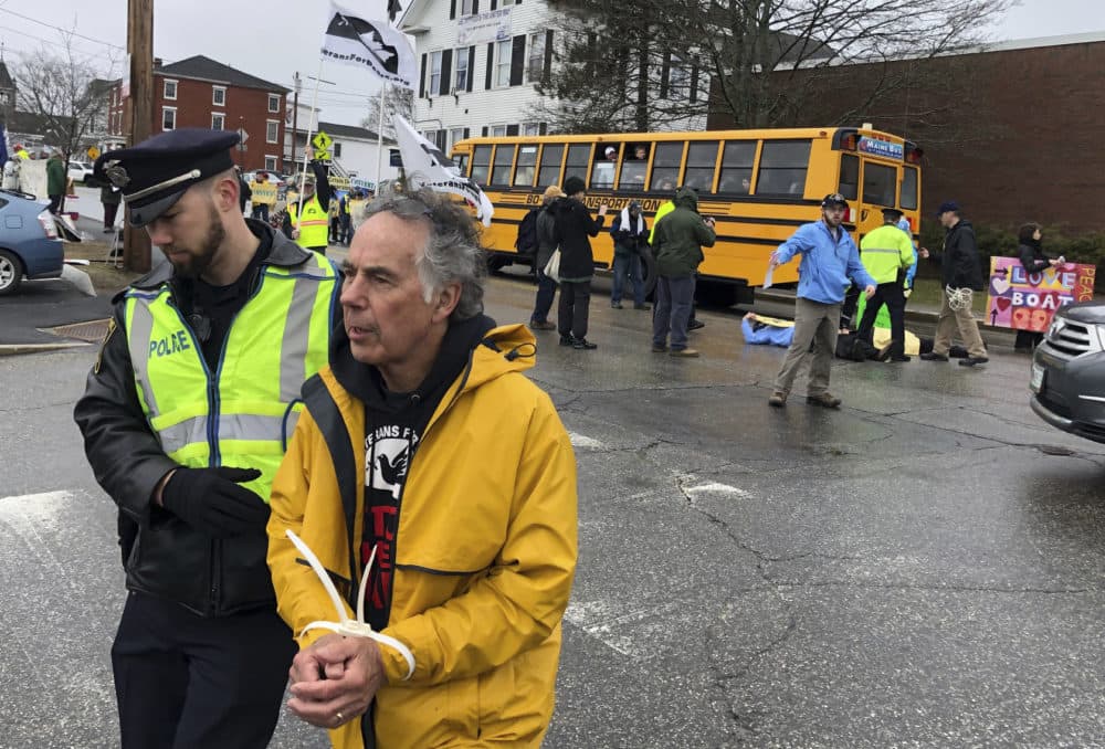 A protester is arrested outside Bath Iron Works prior to the christening ceremony for a Zumwalt-class guided missile destroyer named for former President Lyndon B. Johnson. (David Sharp/AP)