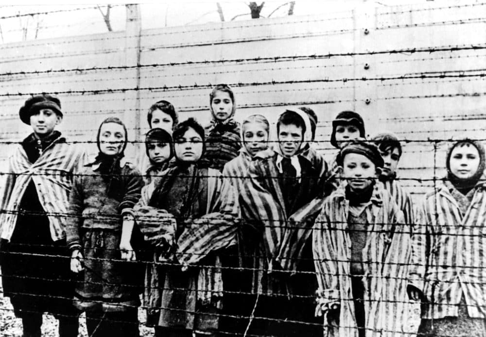 A picture taken just after the liberation by the Soviet army in January, 1945, shows a group of children wearing concentration camp uniforms behind barbed wire fencing in the Auschwitz Nazi concentration camp. (AP file photo)