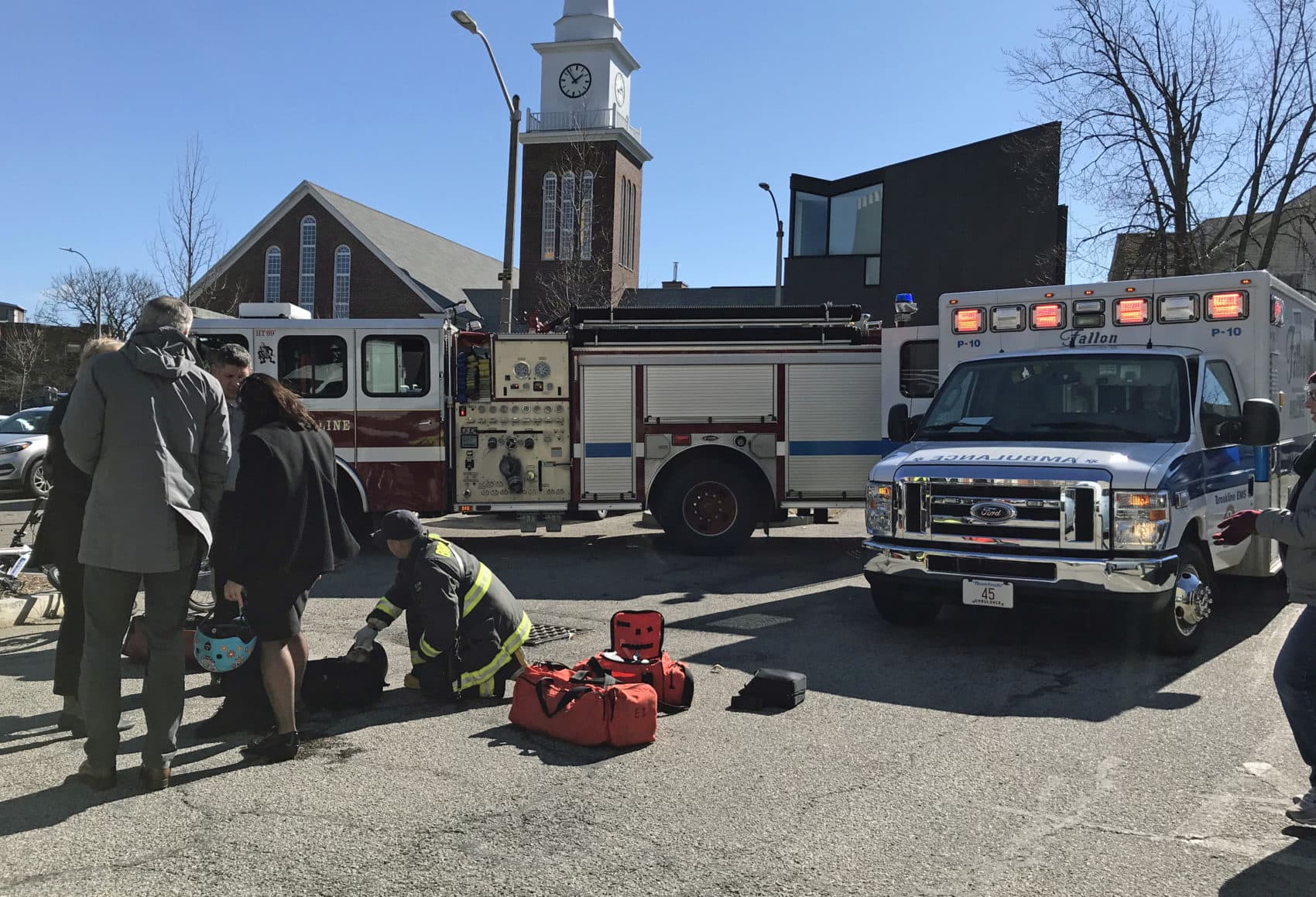 First responders treated a woman after an accident during a launch event for electric scooters in Brookline April 1. (Callum Borchers/WBUR)