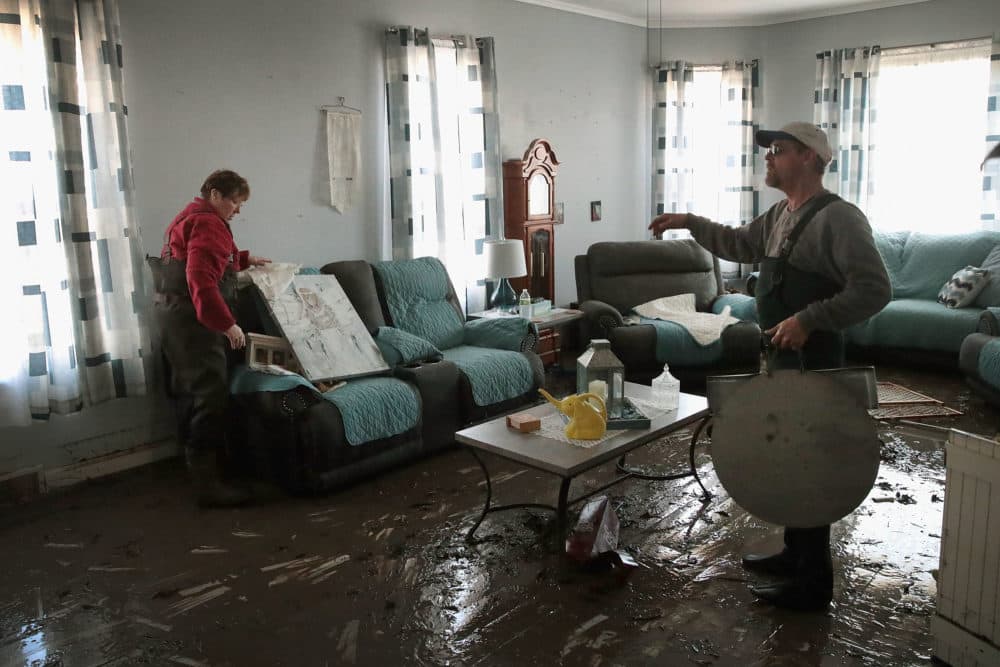 Bill Peeler (right) helps his friend Kathy Drummond remove items from her flooded home on March 20, 2019 in Hamburg, Iowa. (Scott Olson/Getty Images)