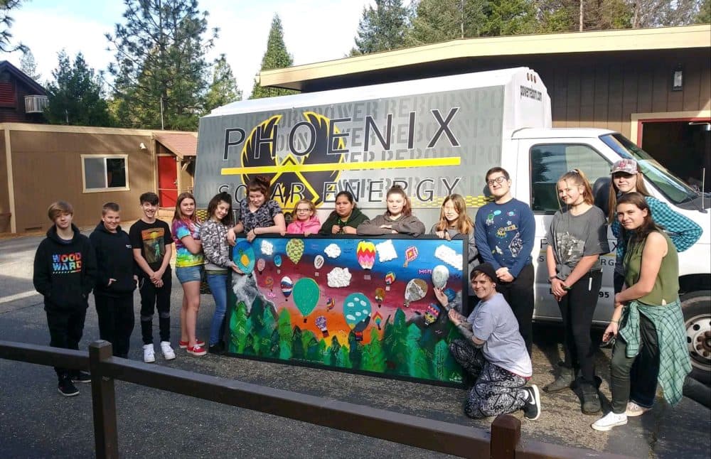 Students display their mural that will eventually hang at the school. (Ashley Bailey/Here &amp; Now)