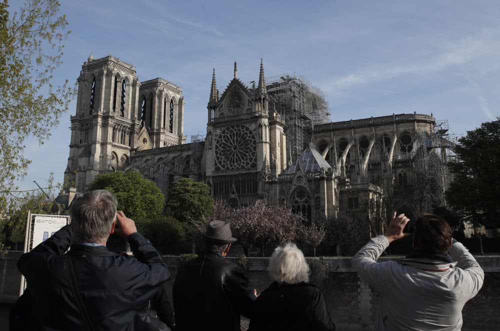 People take photos of the Notre Dame Cathedral from the Left Bank in Paris, Thursday, April 18, 2019.(Christophe Ena/AP)