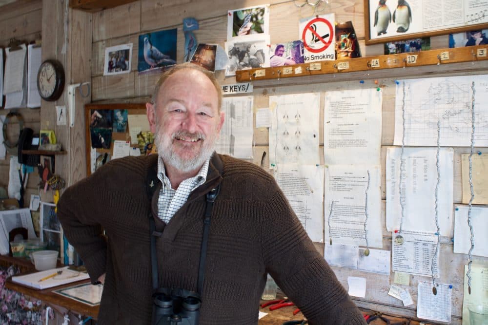 Trevor Lloyd-Evans, an ornithologist at the Manomet Center, stands in bird banding room. (Miriam Wasser/WBUR)