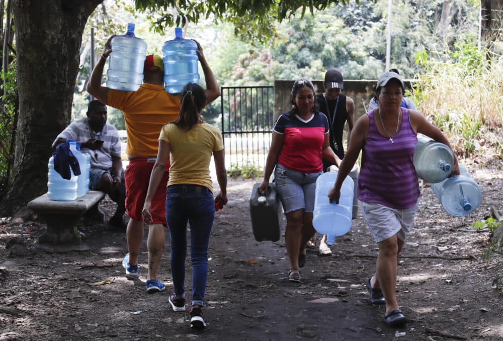 People carry containers to fill with water Avila National Park during rolling blackouts which has cut many off from running water in Caracas, Venezuela, Wednesday, March 13, 2019. Blackouts have marked another harsh blow to a country paralyzed by turmoil as the power struggle between Venezuelan President Nicolas Maduro and opposition leader Juan Guaido stretched into its second month. (Eduardo Verdugo/AP)
