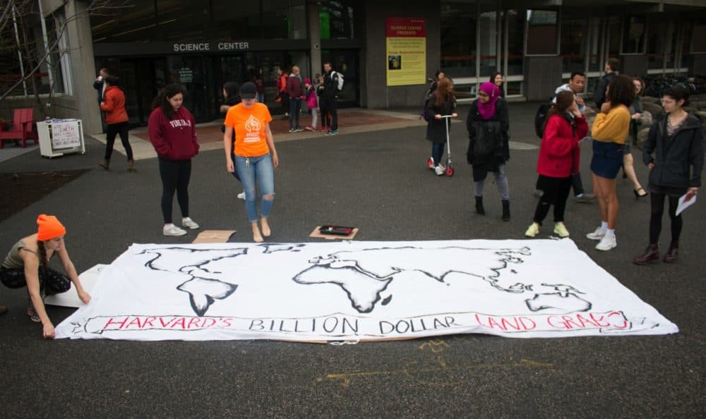 On April 23, Divest Harvard students live-paint a map of what they identify as Harvard’s unsustainable and unethical land investments. (Courtesy of Caleb Schwartz/Divest Harvard)