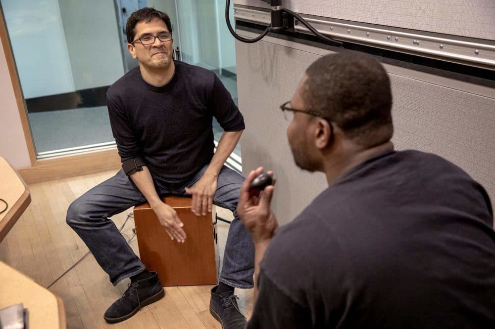 Jorge Perez-Albela plays a cajon, while Jonathan Mande plays cajon and shaker. (Robin Lubbock/WBUR)