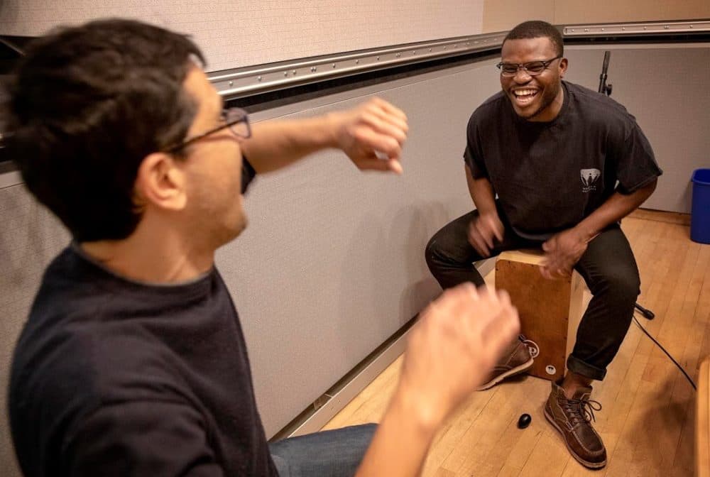 Jonathan Mande plays cajon with Jorge Perez-Albela at WBUR’s studios. (Robin Lubbock/WBUR)