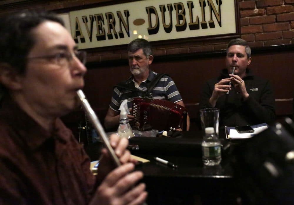 Leslie Kurtzberg, left, plays a penny whistle during an Irish music session at the Green Briar pub. (Hadley Green for WBUR)