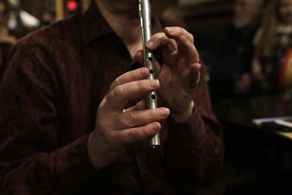 Leslie Kurtzberg plays a penny whistle during an Irish music session at the Green Briar pub. (Hadley Green for WBUR)
