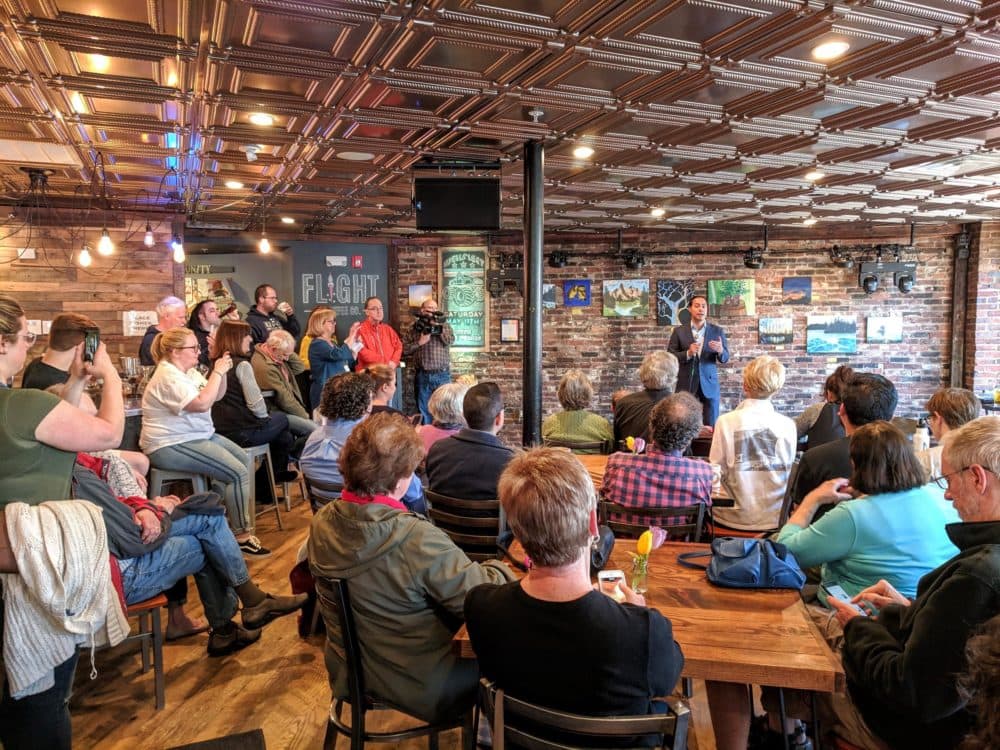 Former Housing and Urban Development Secretary Julián Castro speaks at Flight Coffee in Dover, as bird-doggers and other voters listen and wait to ask questions. (Jason Moon/NHPR)