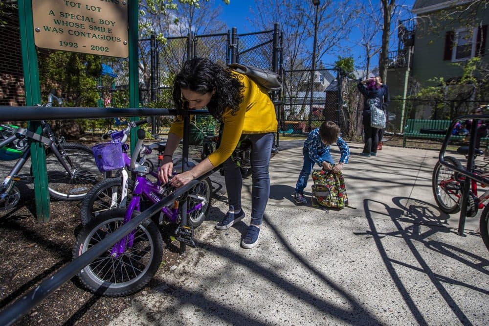 Elizabeth Pinsky unlocks her son Ben's bicycle before heading home for the day. (Jesse Costa/WBUR)